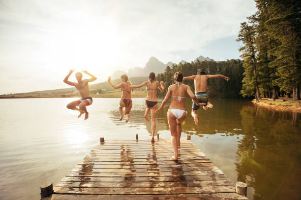 istock Young friends jumping into a lake 512747280