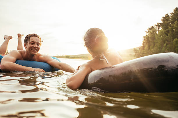 istock Affectionate young couple floating on inner tubes in lake 512747368