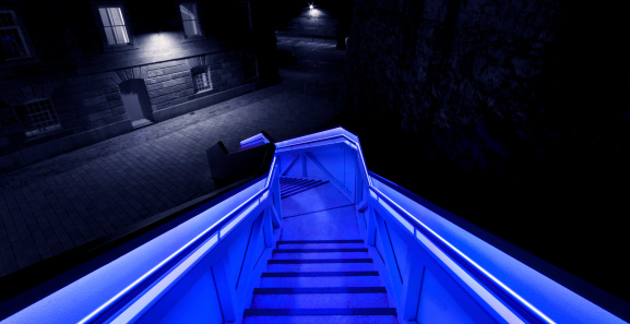 An illuminated staircase leads into the Royal William Yard in Plymouth, Devon. England. The staircase cycles through all the colours of the rainbow.