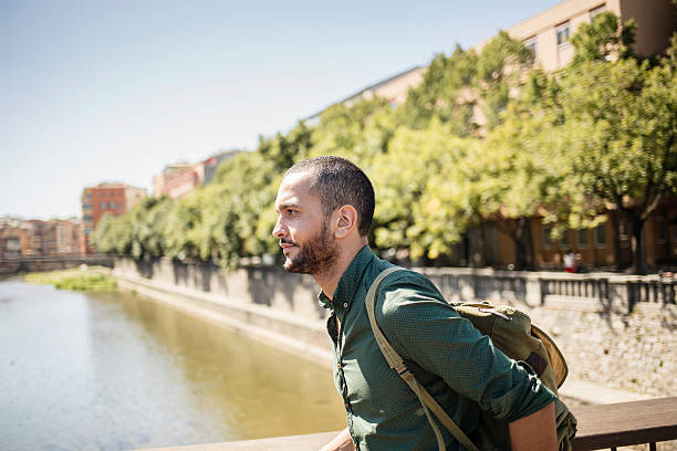 istock Handsome bearded man walking on bridge and looking away 512747762