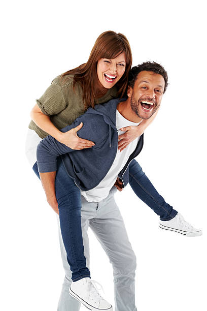 Happy mature couple piggybacking on white Portrait of happy mature couple piggybacking on white background couple isolated wife husband stock pictures, royalty-free photos & images