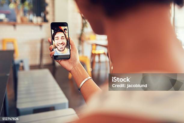 Woman Having A Video Call With Man On Her Phone Stock Photo - Download Image Now - Video Call, Telephone, Over The Shoulder View