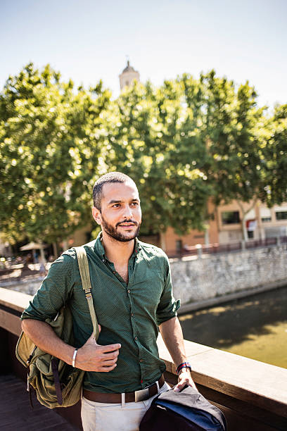 istock Handsome bearded man walking on bridge and looking away 512747984
