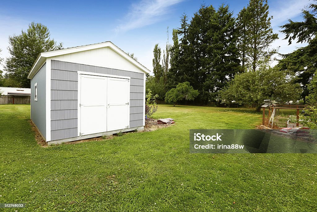 Small grey shed with white trim. Countryside real estate Countryside landscape with small grey and white shed Shed Stock Photo