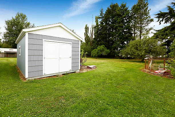 Small grey shed with white trim. Countryside real estate stock photo