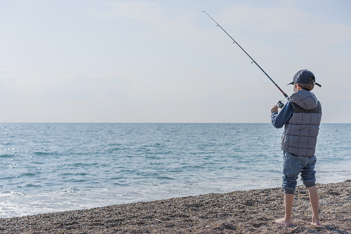 young boy fishing,sea