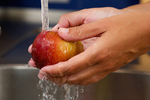 istock Female hands holding apple under water 512748759