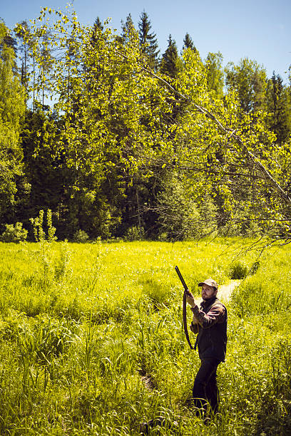 istock Mid Aged Man With A Gun Standing in a Marshland 512748846