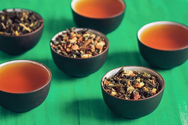 istock Dry exotic tea with spices in dark ceramic bowls 512749202