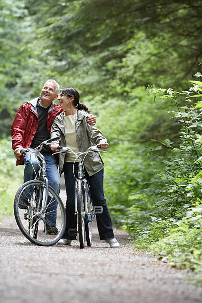 istock Middle Aged Couple With Bikes On Forest Road 512749617