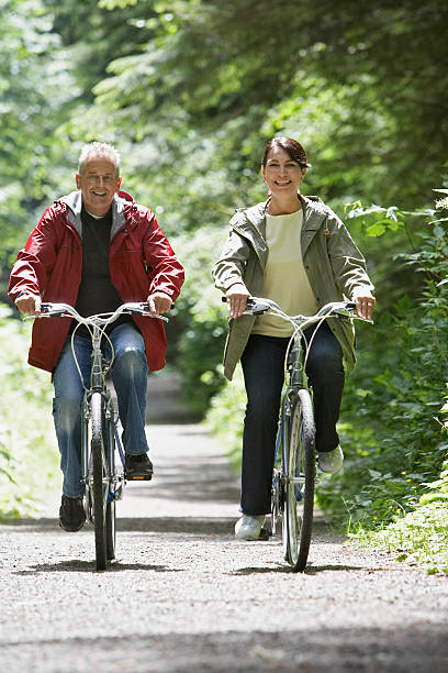 istock Middle Aged Couple Biking On Forest Road 512749621
