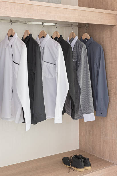 istock shirts hanging on rail in modern wooden wardrobe 512749624
