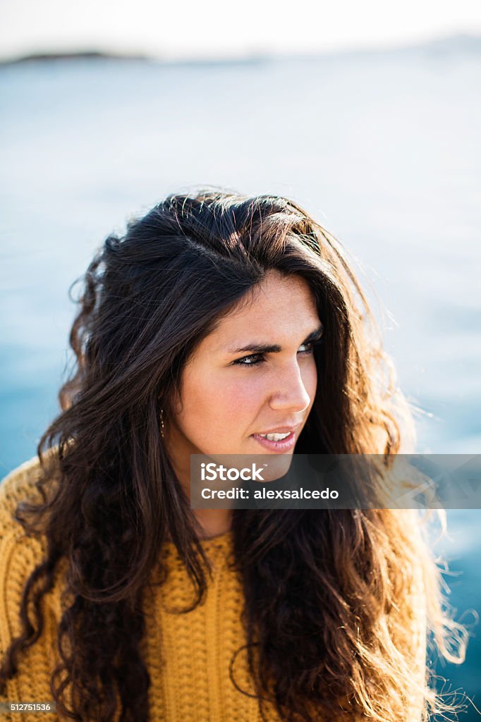 Portrait of young woman looking away while sitting on pier Portrait of young woman looking away while sitting on pier.Summertime Adult Stock Photo