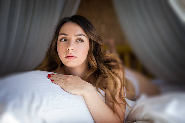 istock Girl in bed hugging a pillow 512753334
