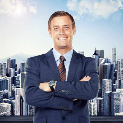 Portrait of a successful young businessman standing in front of a city skyline