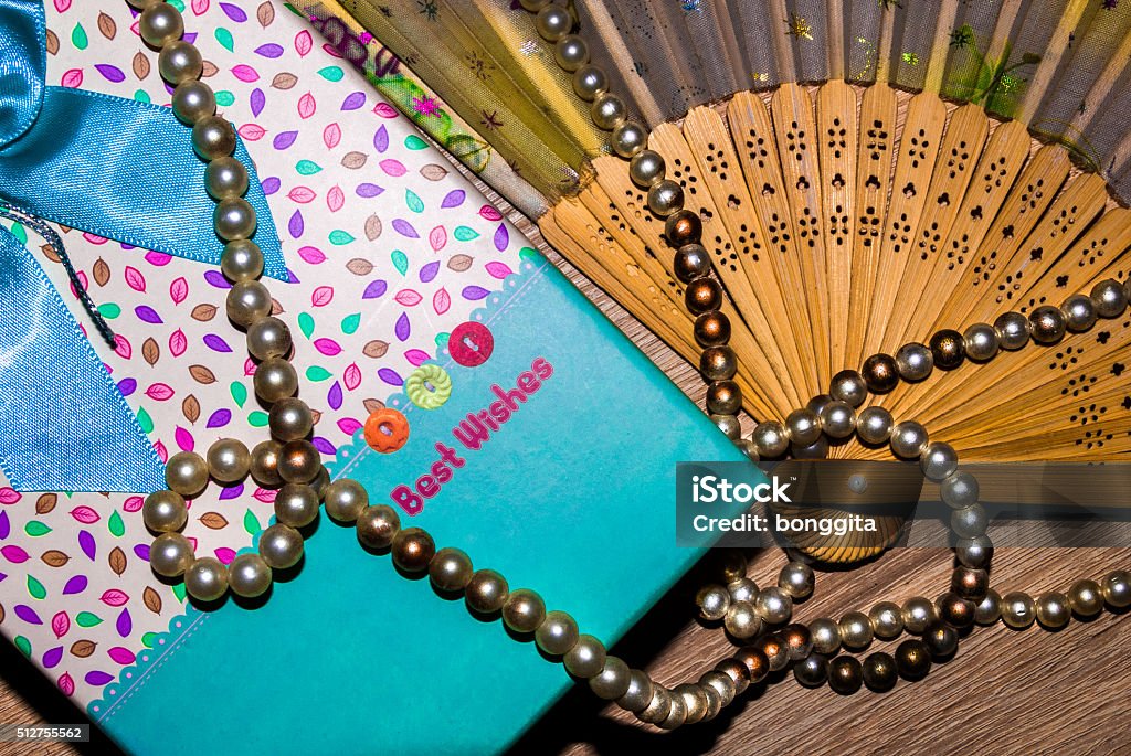 Presents Vintage wooden fan, present box with some pearls, stylish present composition. Bachelorette Party Stock Photo
