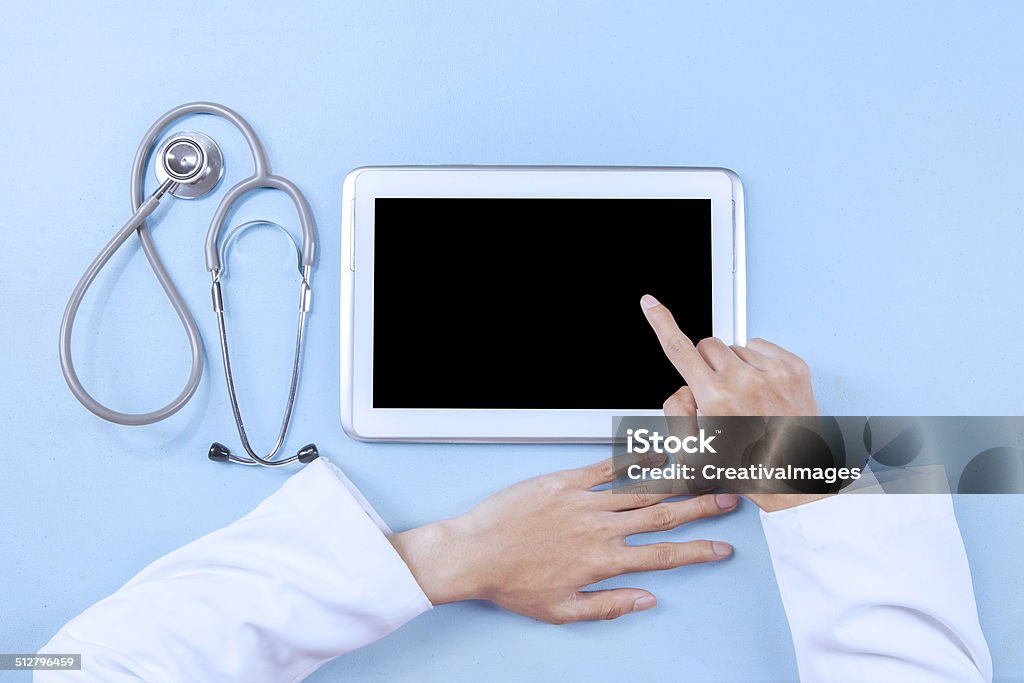 Doctor working on a digital tablet Doctor working on a digital tablet and touching the screen Adult Stock Photo