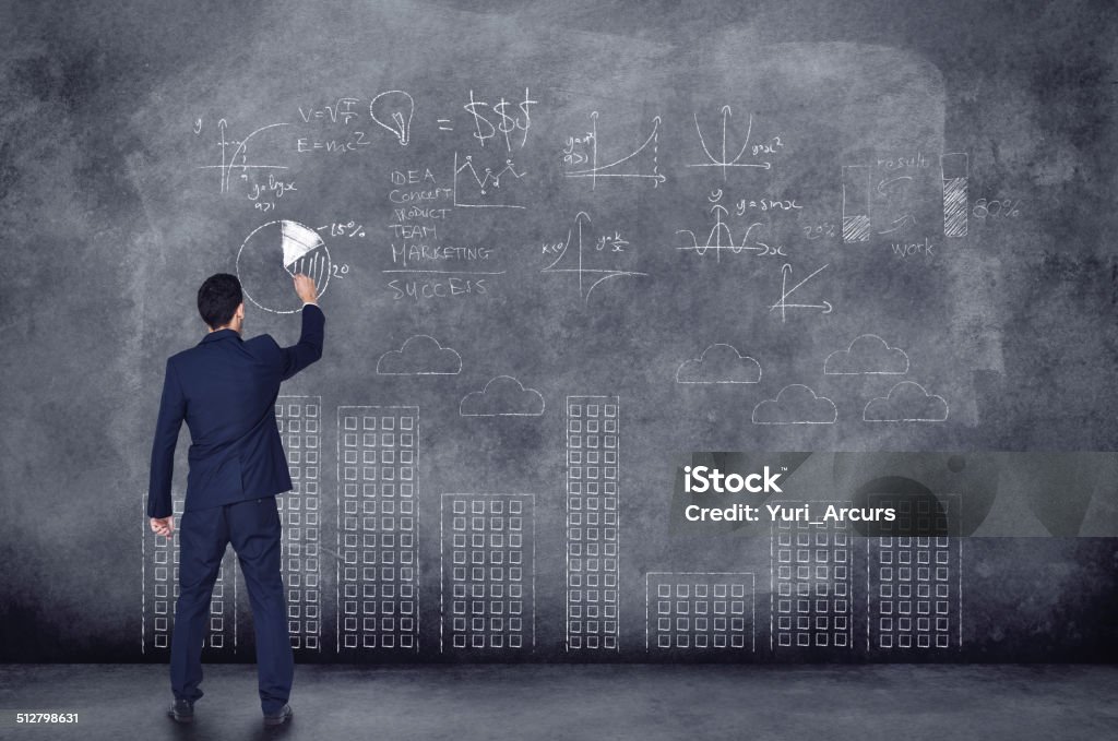 Business analysts..geniuses of the corporate world! A rear view of a businessman performing calculations on a black backgroundhttp://195.154.178.81/DATA/i_collage/pi/shoots/784158.jpg Chalkboard - Visual Aid Stock Photo