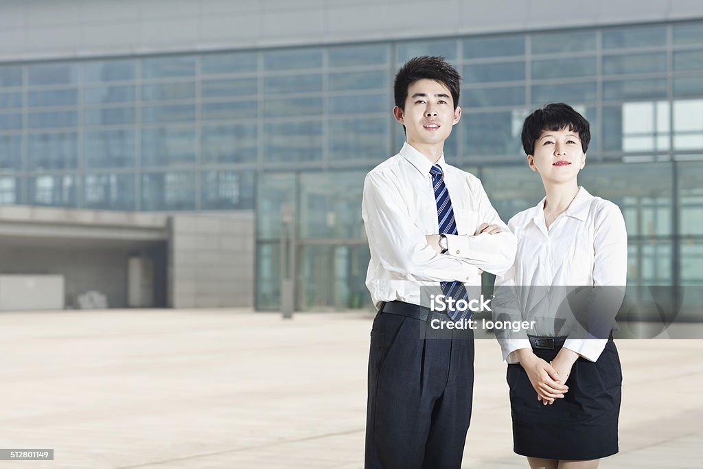 Two successful business people standing outdoor Portrait of two East Asina business people smiling with arms crossed outdoor 20-29 Years Stock Photo