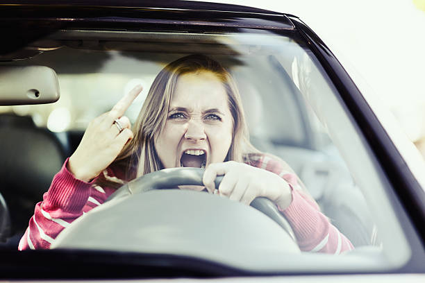 istock Raging woman driver makes obscene gesture through windshield, yelling abuse 512801335