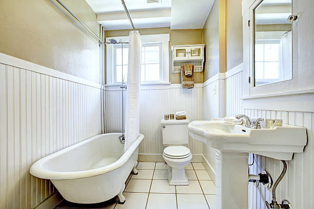 Claw foot tub in white bathroom Claw foot tub in bright bathroom with white wall trim, washbasin stand and toilet free standing bath stock pictures, royalty-free photos & images