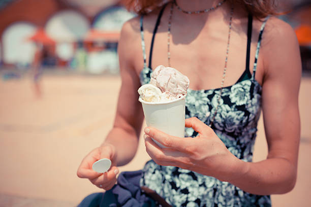 istock Woman eating ice cream on the beach 512802467