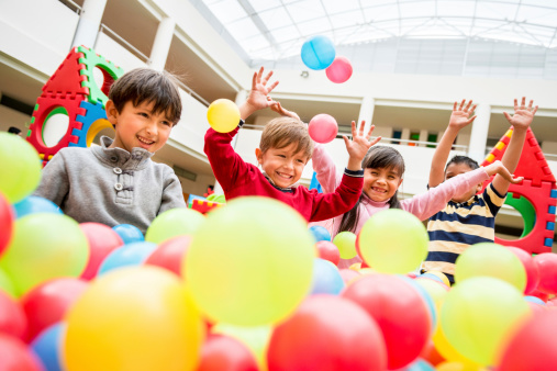 Happy group of kids playing at a ball pool