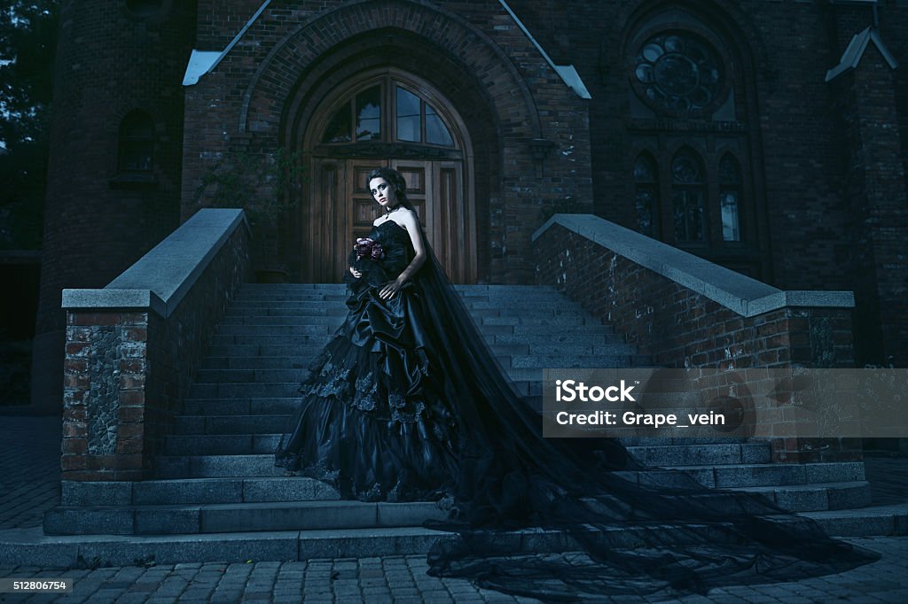Mysterious woman in black dress near chirch Woman in black gothic dress near chirch Gothic Style Stock Photo