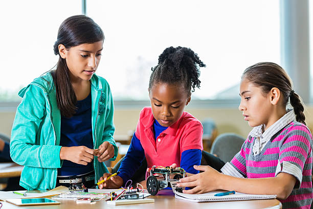 istock Little girls building robots during science class after school 512807584