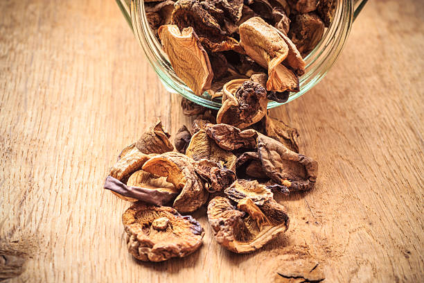 istock Dry mushrooms in jar on wooden table. 512809132
