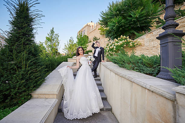 istock bride and groom walking up the stairs in park 512813182