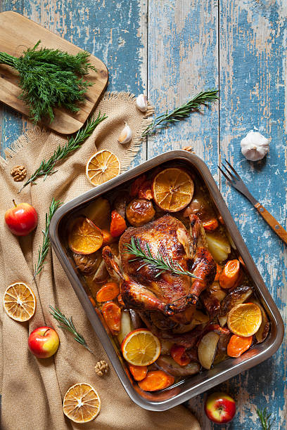 istock Roasted chicken with vegetables and herbs on vintage wooden table 512813338