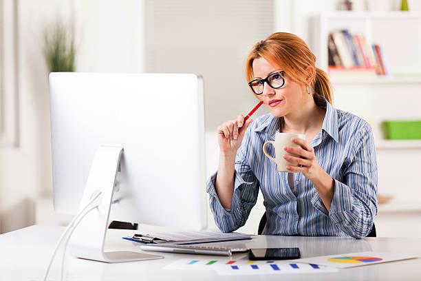 istock Pensive businesswoman holding cup of coffee and using computer. 512818642