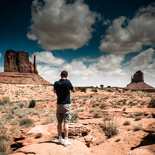 istock tourist standing against the monument valley landscape 512818996
