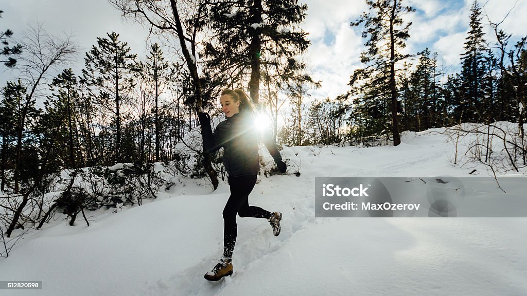 Girl running in winter forest Photo of a girl running in a winter forest covered with snow. Shot in Bergen, Norway Active Lifestyle Stock Photo