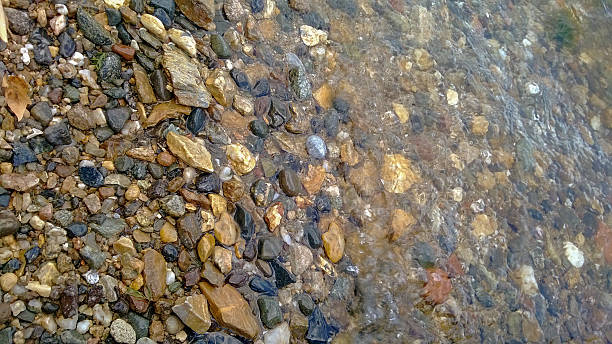 istock Colorful pebbles over and under sea water 512824916