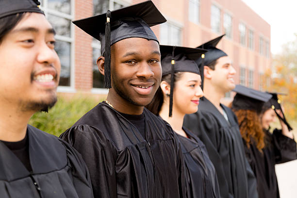 la educación : descendencia africana macho graduado y amigos en colegio campus. - early teens teenager adult student people in a row fotografías e imágenes de stock