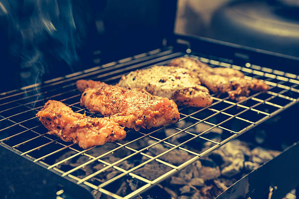 istock Grilled chicken with black pepper on a barbecue and smoke. 512827562