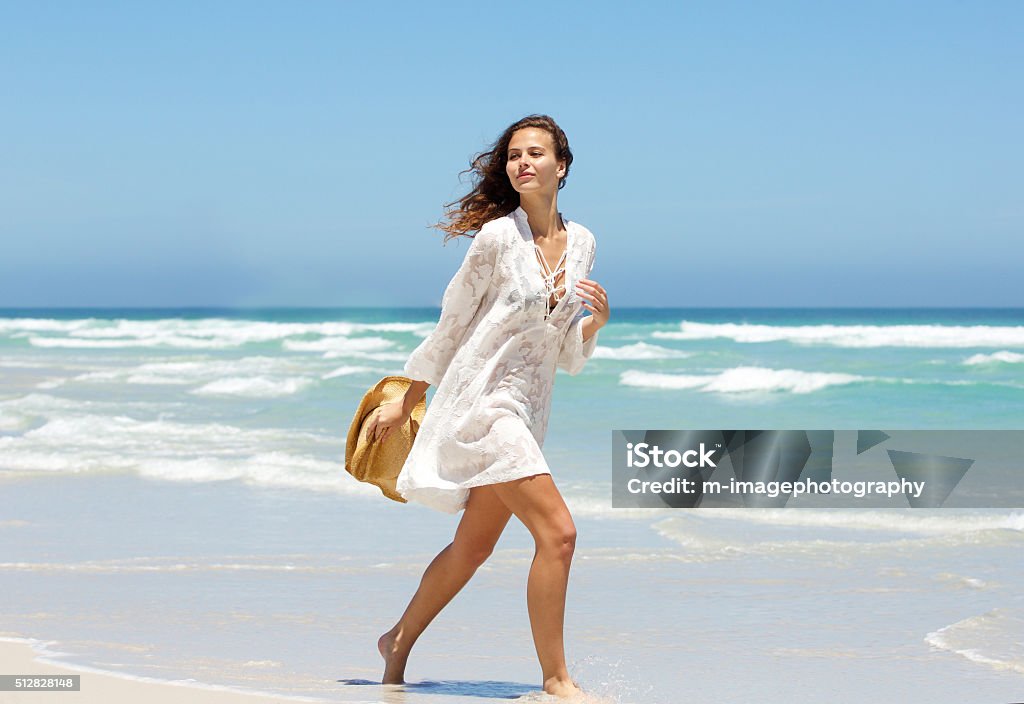 Hermosa Mujer Joven Caminando En La Playa Durante El Verano Vestir Foto de  stock y más banco de imágenes de Playa - iStock