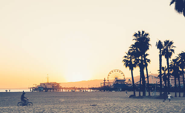 santa monica beach und pier bei sonnenuntergang - santa monica santa monica beach beach california stock-fotos und bilder