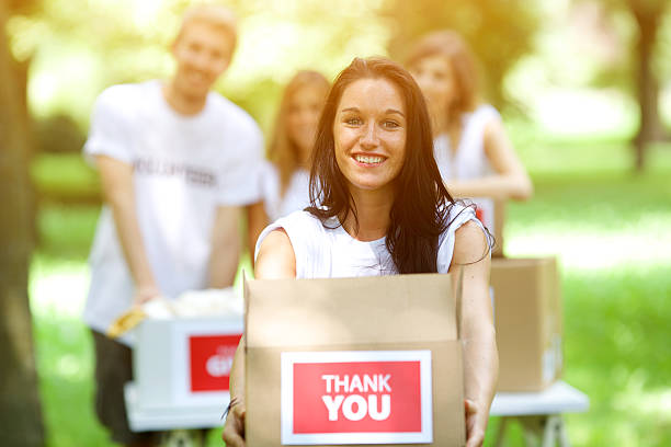 istock Young woman holding a donation box 512829737