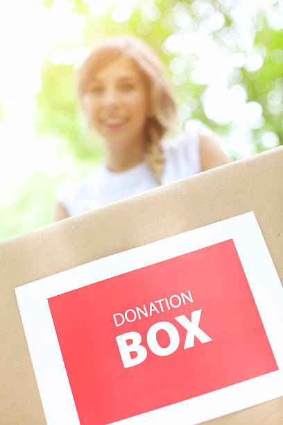 istock Young woman holding a donation box 512829743
