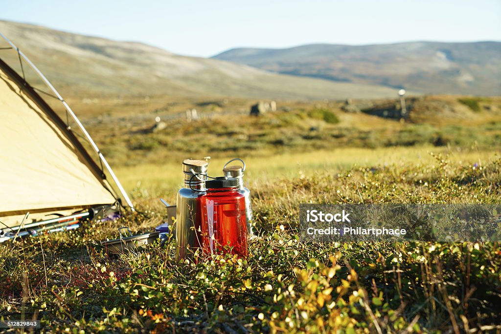 close up of water bottles in meadow beside a tent Close up of outdoor water bottles standing beside a tent in the meadow. Picturesque scenic view of grassland and remote hills in the Jotunheimen national park, Norway. Nobody. XXXL (Sony Alpha 7R) Close-up Stock Photo