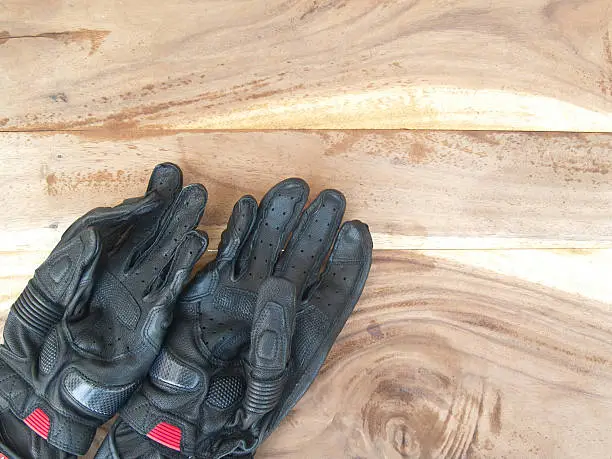 Photo of black gloves motorcycle on old wood table