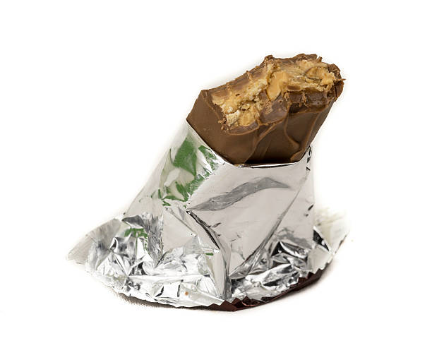 istock Milk chocolate bar with nuts wrapped on shining foil wrapper 512831519