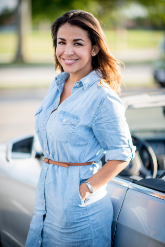 Summer woman looking very happy next to her car