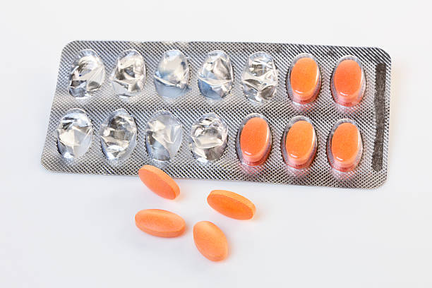 Statin Pills with Opened Blister Pack Statin pills with a used blister pack in the background. Shallow dof. Logos Removed statin stock pictures, royalty-free photos & images