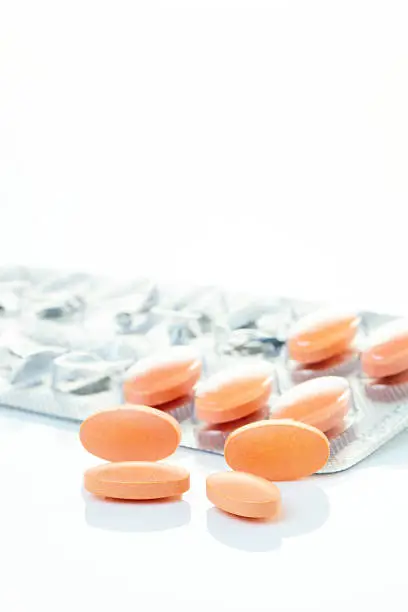 Statin pills with a used blister pack in the background. Shallow dof. Logos Removed