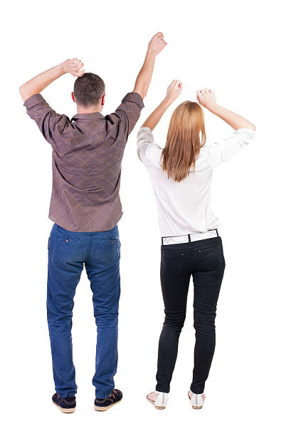 istock Back view of  joyful couple celebrating victory hands up. 512835813