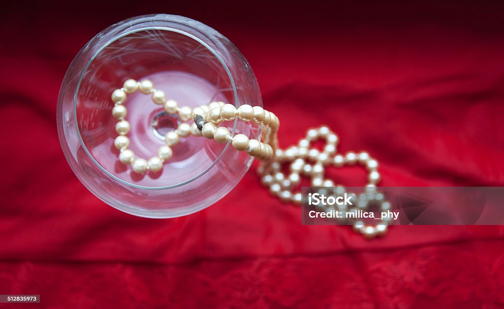 pearls in wine glass white pearls in wine glass on red silk Beauty Stock Photo